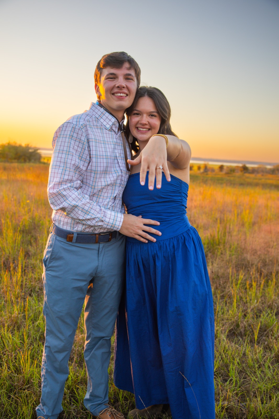 She shows off the ring in a tall grass field after the proposal, engagement session in Mississippi