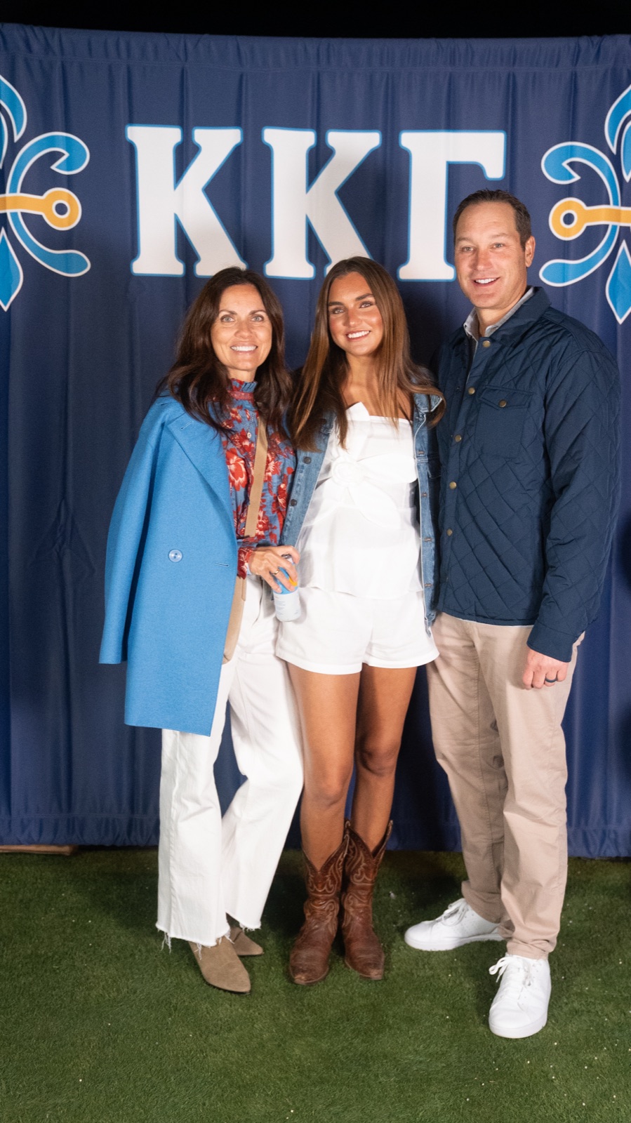 Family of three at the Kappa Kappa Gamma parents weekend backdrop, Ole Miss, Oxford MS