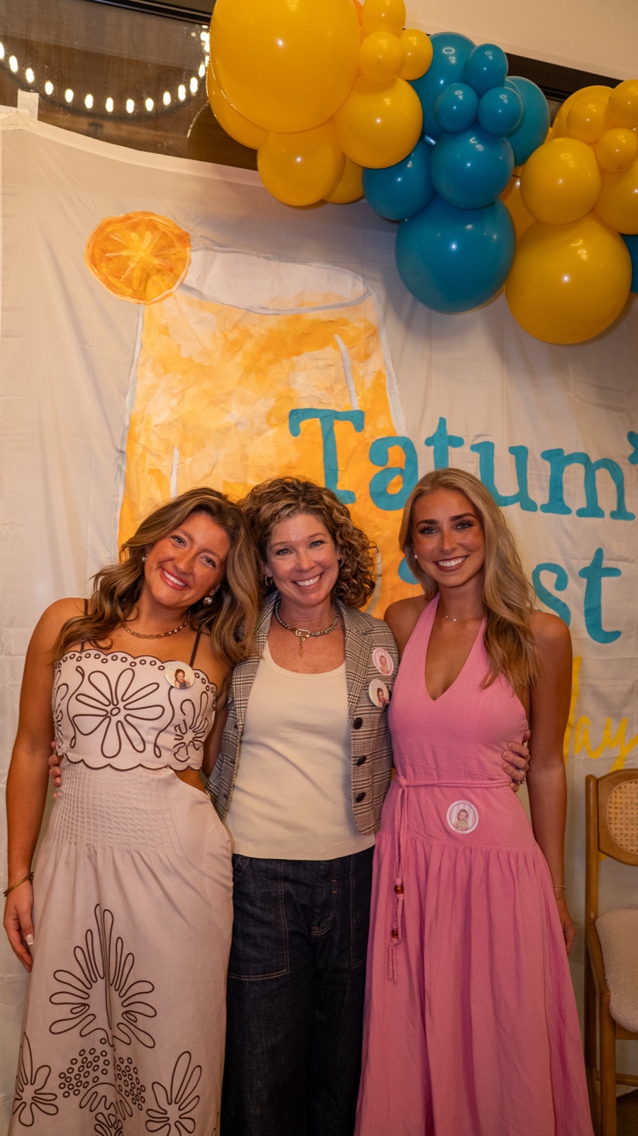 Three friends in front of a custom 21st birthday banner and balloon garland, party photography in Oxford, Mississippi