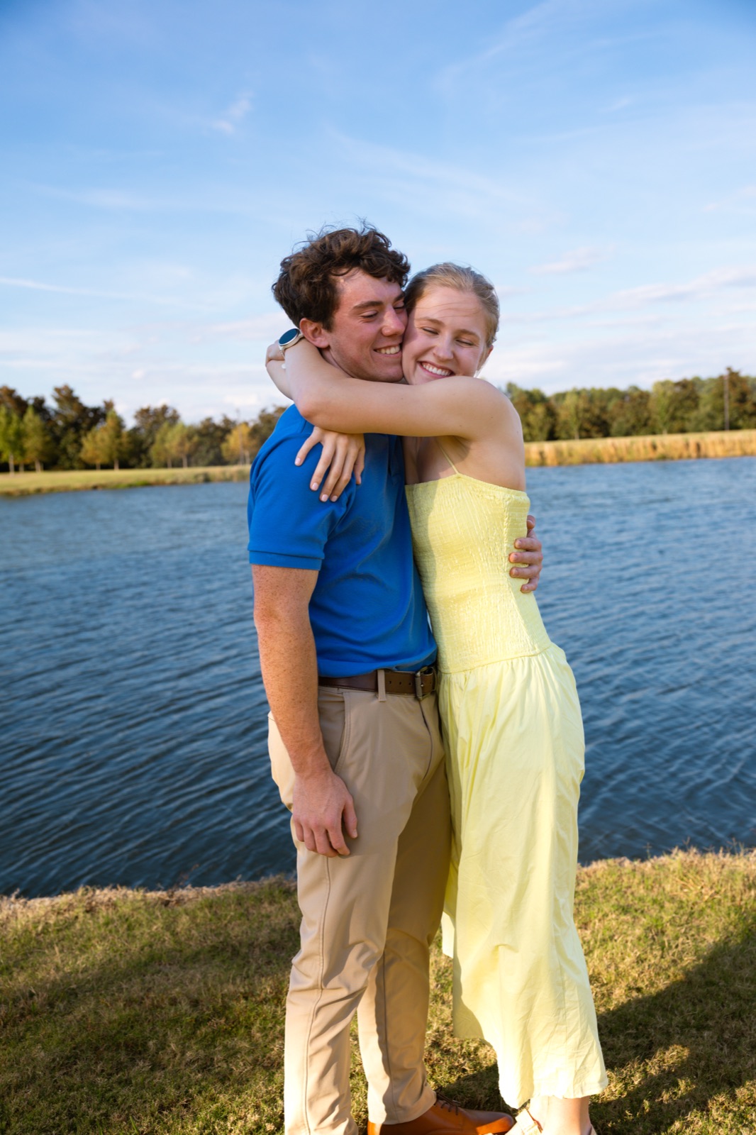 Engaged couple embracing by the water